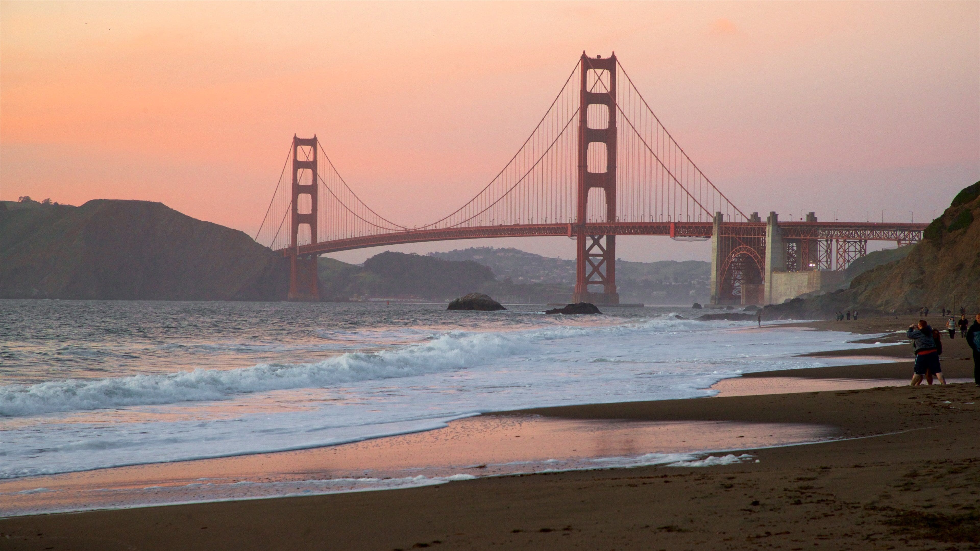 Golden Gate Bridge showing waves, a sunset and a bridge