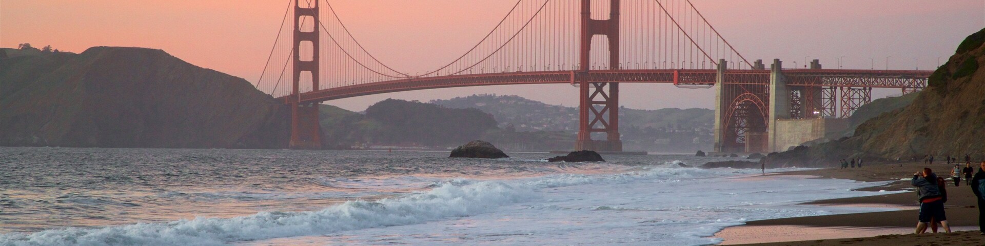 Golden Gate Bridge showing waves, a sunset and a bridge