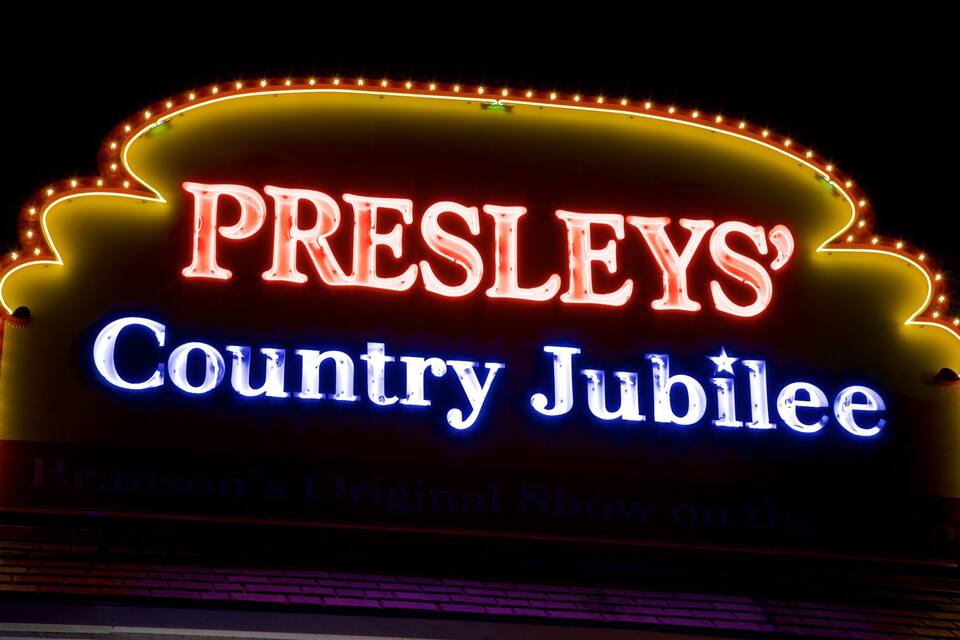 A neon sign for 'Presley's Country Jubilee' with a star above the word 'Jubilee'.