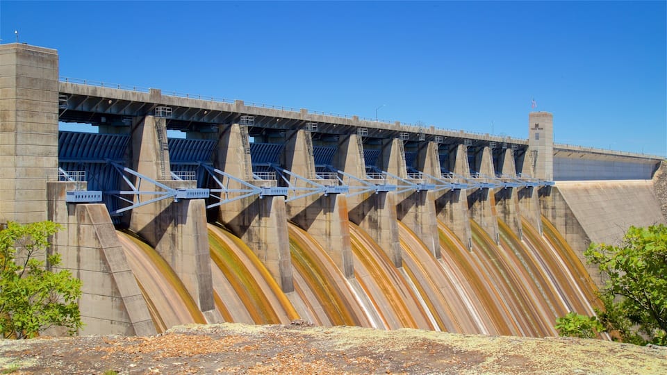 A large dam with multiple spillways and a bridge crossing over it.