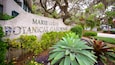 A sign for Marie Selby Botanical Gardens surrounded by lush greenery and trees.