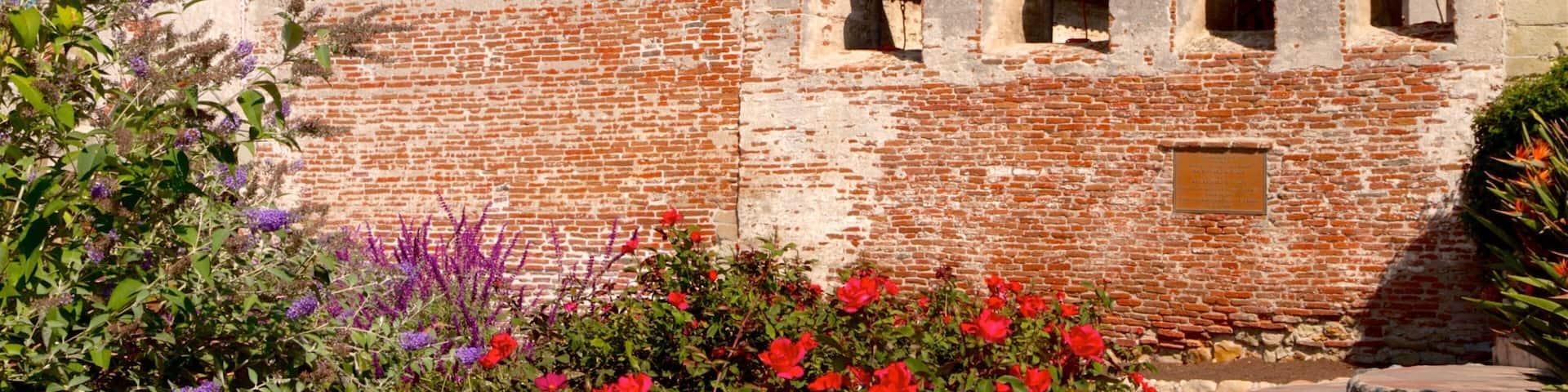 A historic brick building with a bell tower and arched windows.