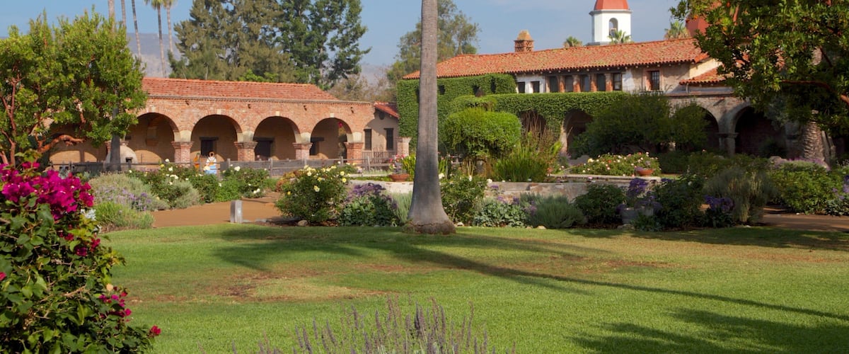 Mission San Juan Capistrano das einen Blumen, historische Architektur und Garten
