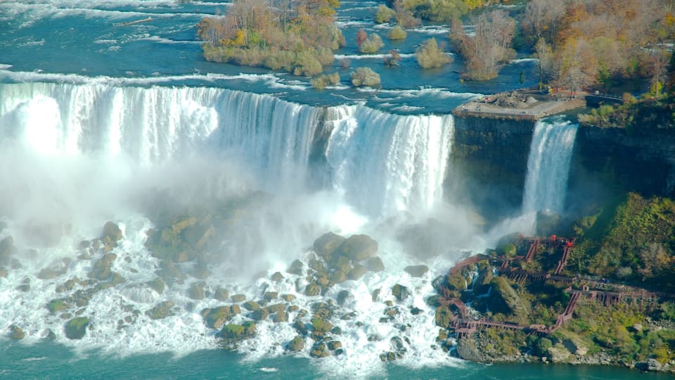 A large waterfall with multiple cascades, surrounded by rocky terrain and trees.