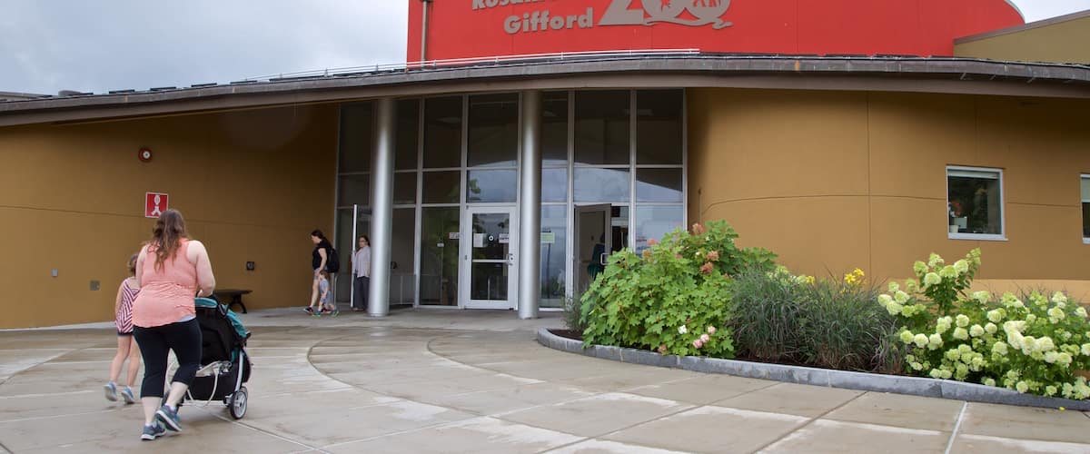 Rosamond Gifford Zoo which includes zoo animals and signage as well as a family