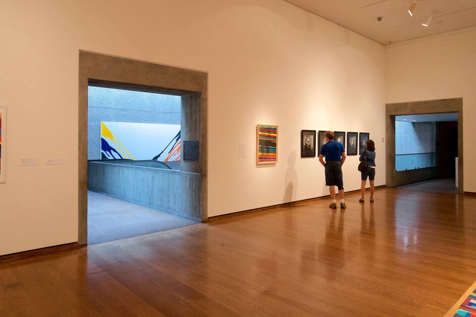 An art gallery with wooden floors and white walls.