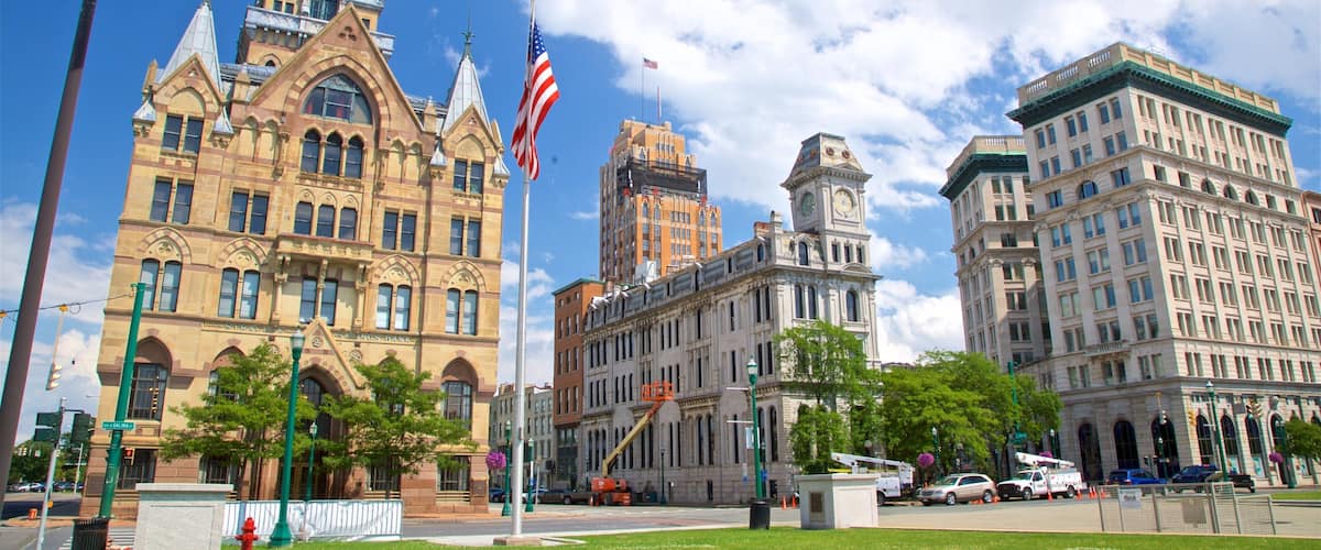 A historic building with a clock tower, a large flag, and a construction crane.
