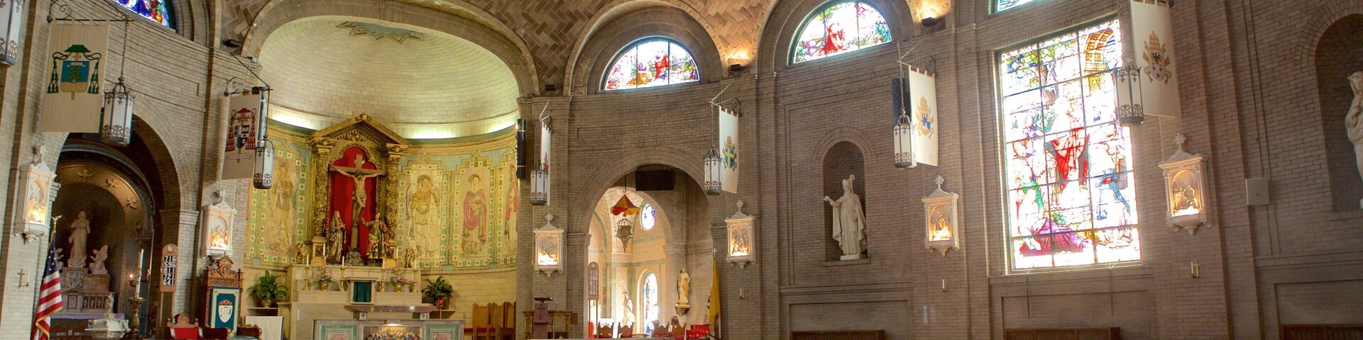 A church interior with wooden pews, stained glass windows, and a central altar.