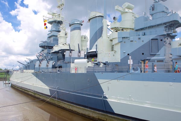 Battleship Carolina del Norte mostrando elementos del patrimonio y también un pequeño grupo de personas