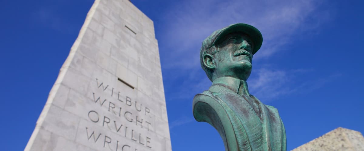 A monument with inscriptions and a bronze bust.