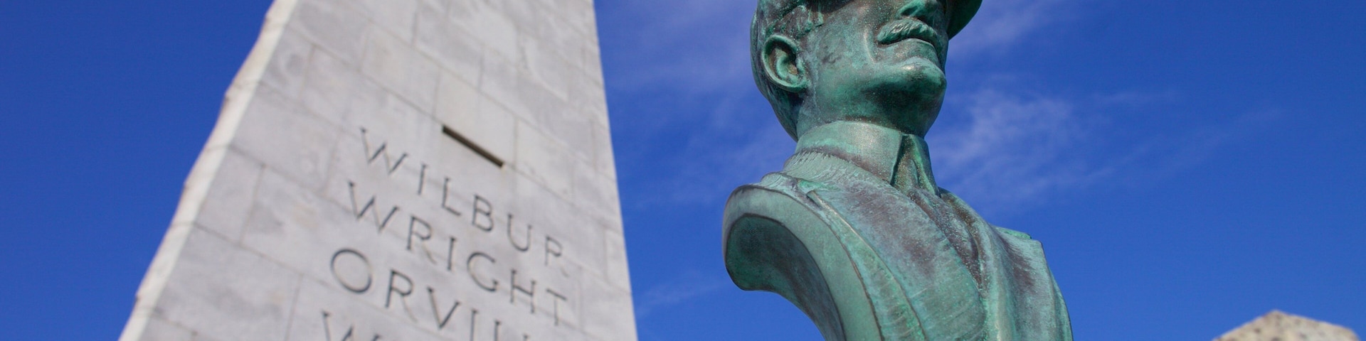 A monument with inscriptions and a bronze bust.
