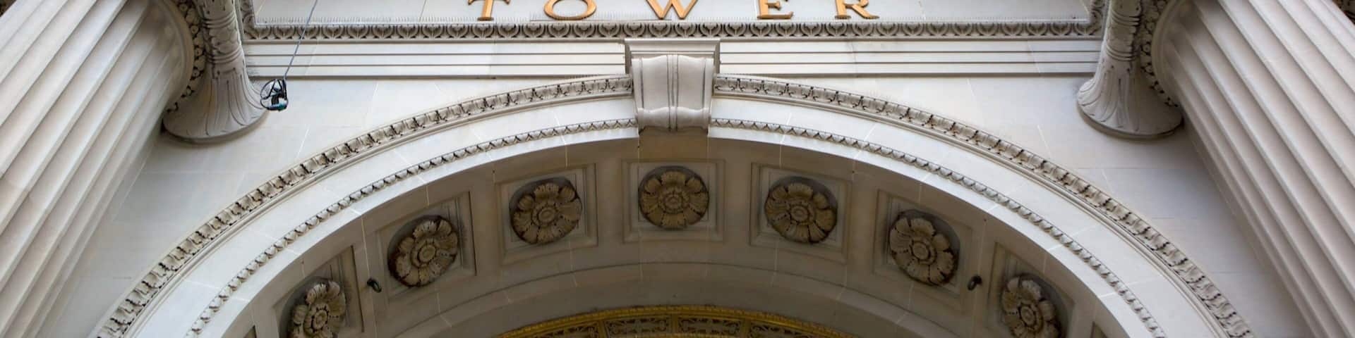 An ornate arched entrance with the word "TOWER" inscribed above it.