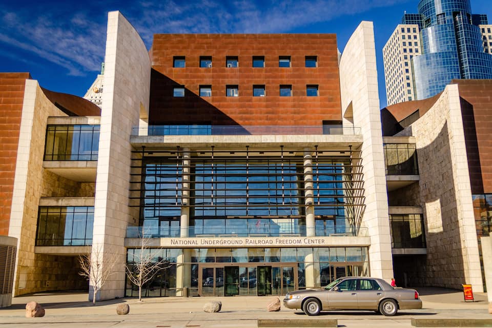 Een modern gebouw met een glazen gevel en de tekst 'National Underground Railroad Freedom Center'.