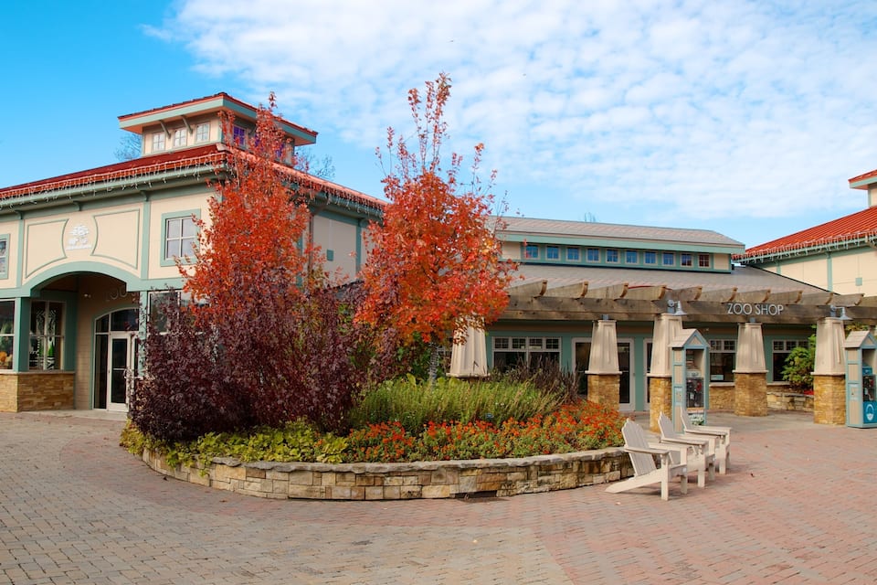 A building with a red roof and a sign that reads "ZOO SHOP".