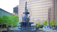 A fountain with statues in a city square.