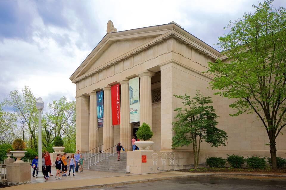 A classical building with columns, banners, and a staircase leading to the entrance.