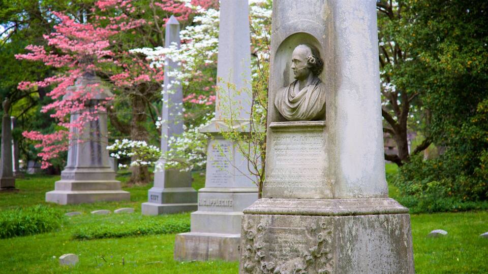 Ein Friedhof mit Grabsteinen, darunter einer mit einer Büste und Inschriften.