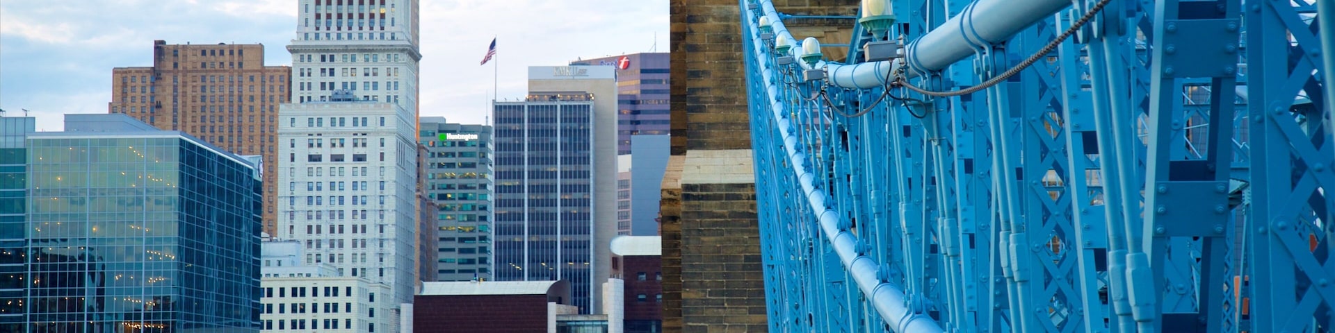 A blue bridge with pedestrians, a city skyline with a prominent building labeled 'PNC', and modern architecture.
