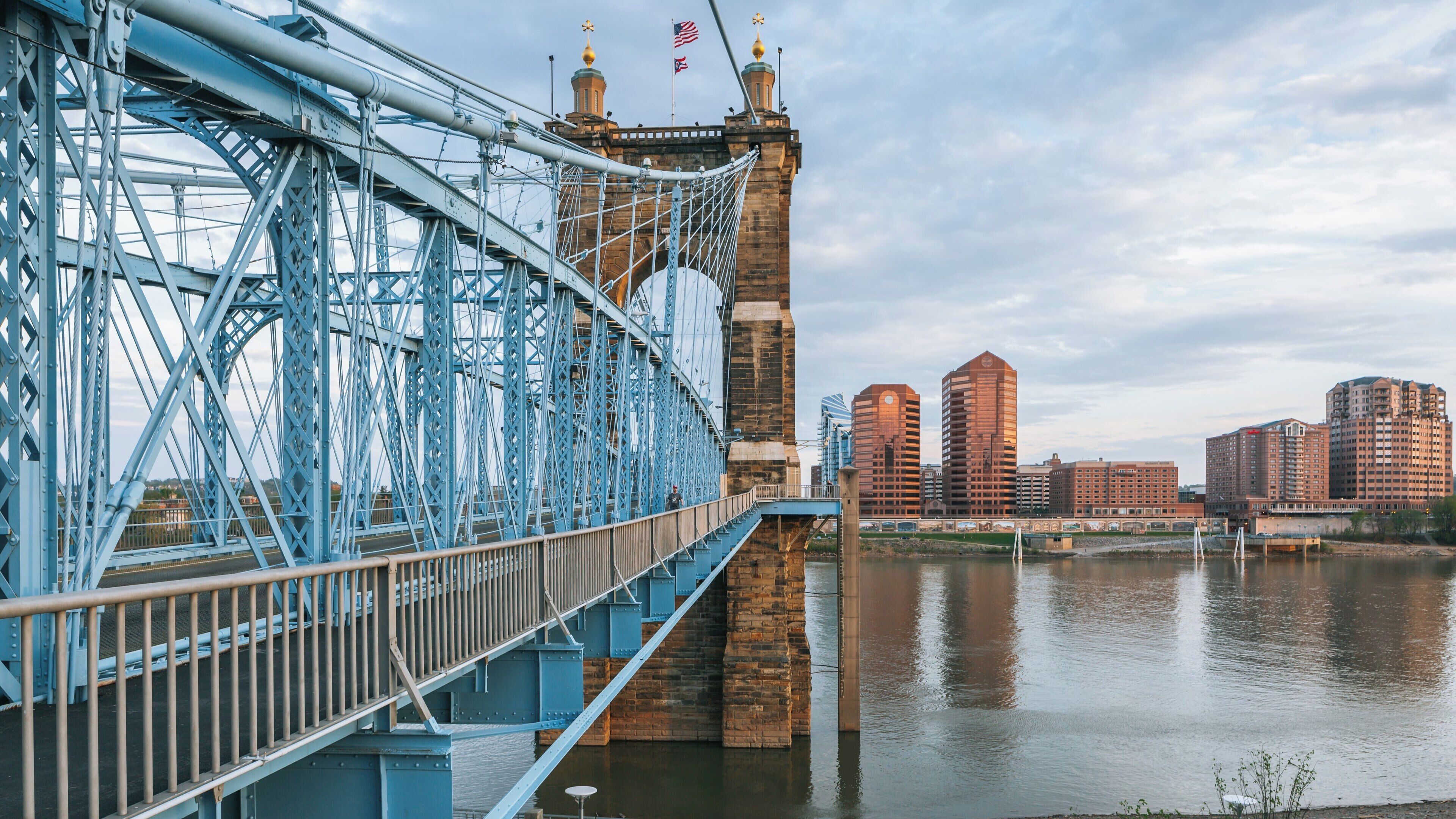 John A. Roebling Suspension Bridge spans across the Ohio River connecting Cincinnati to Covington with impressive architecture and city backdrop