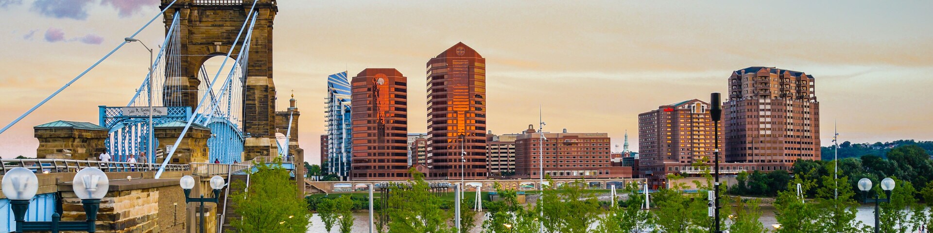 A cityscape with a prominent bridge, modern high-rise buildings, and a well-maintained park area.
