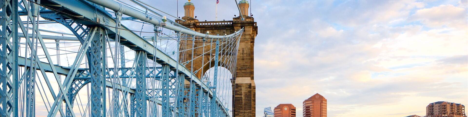 John A. Roebling Suspension Bridge showing a river or creek, heritage elements and a sunset