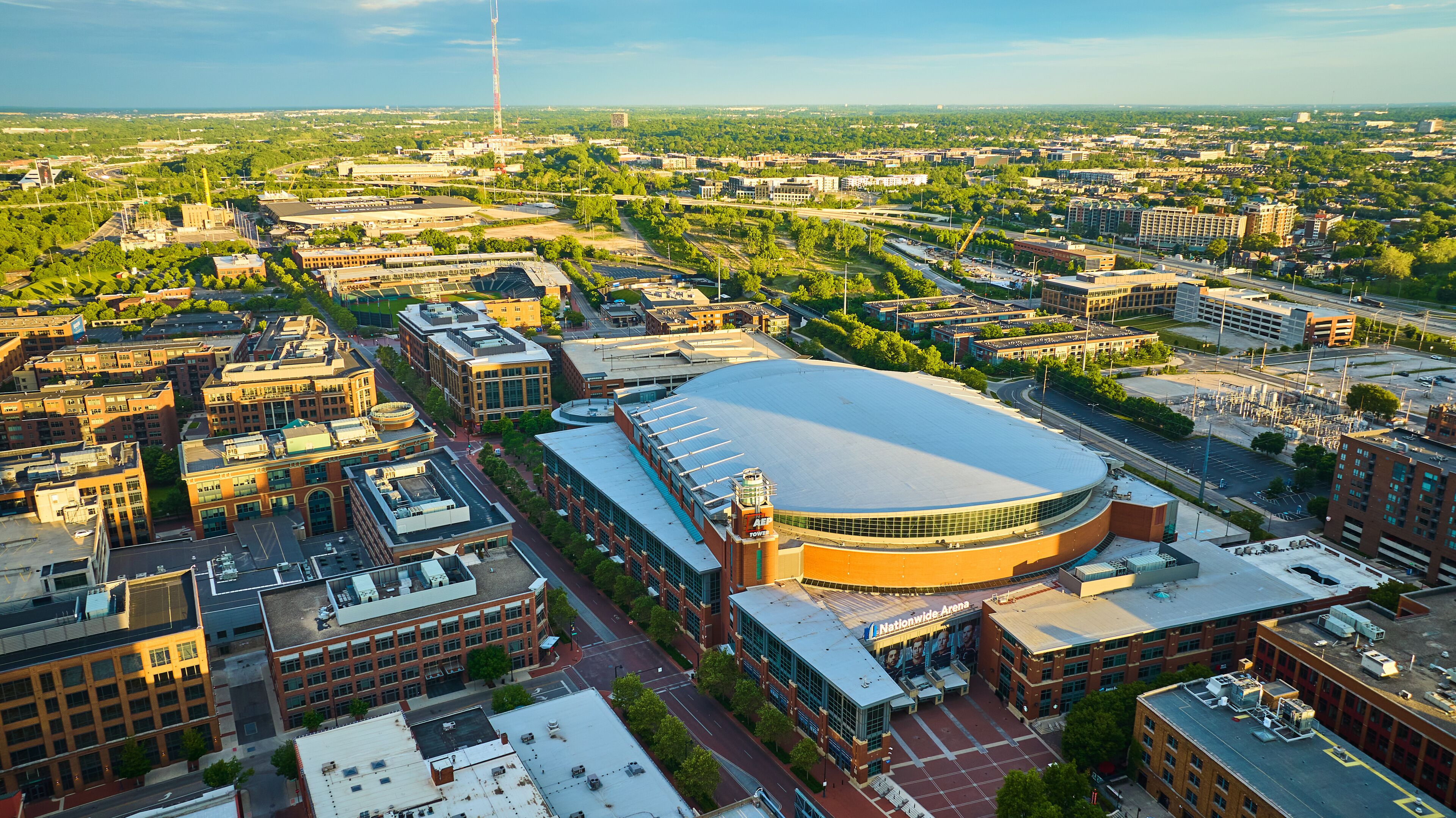 Golden sunrise over Nationwide Arena and land around it in aerial of Columbus Ohio