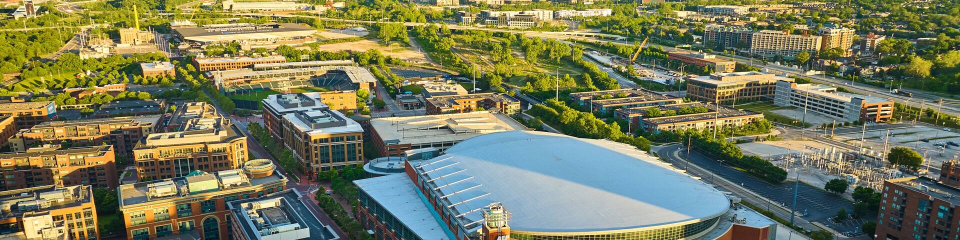 Golden sunrise over Nationwide Arena and land around it in aerial of Columbus Ohio