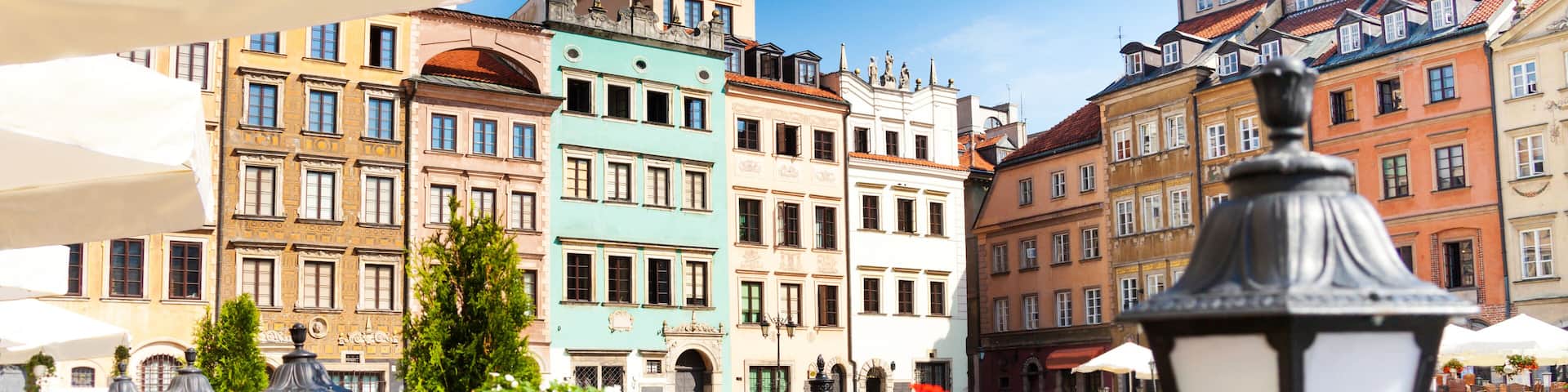 Warsaw old town marketplace square, street lamp in cafe and flowers on foreground