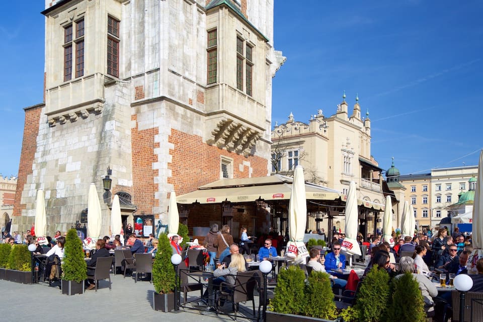 A bustling outdoor café area with stone buildings and outdoor seating.