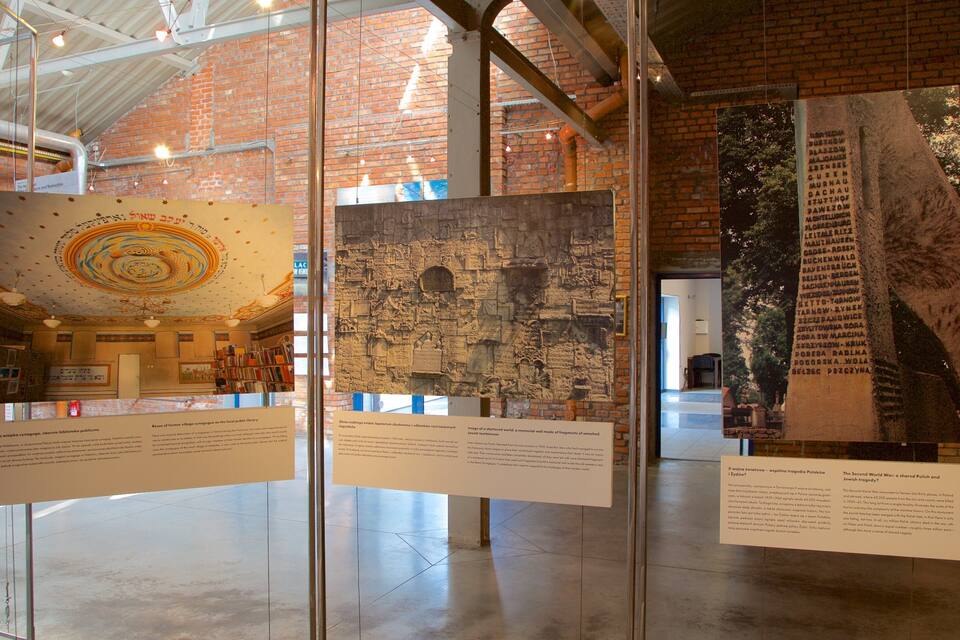 A museum interior with brick walls, glass display cases, and informational plaques.