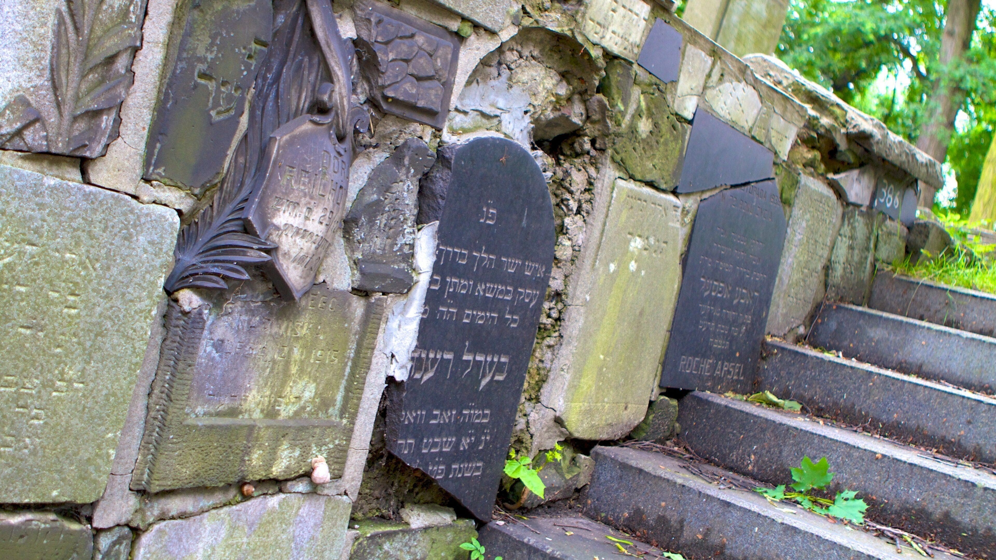Un muro de piedra con placas grabadas y escalones.