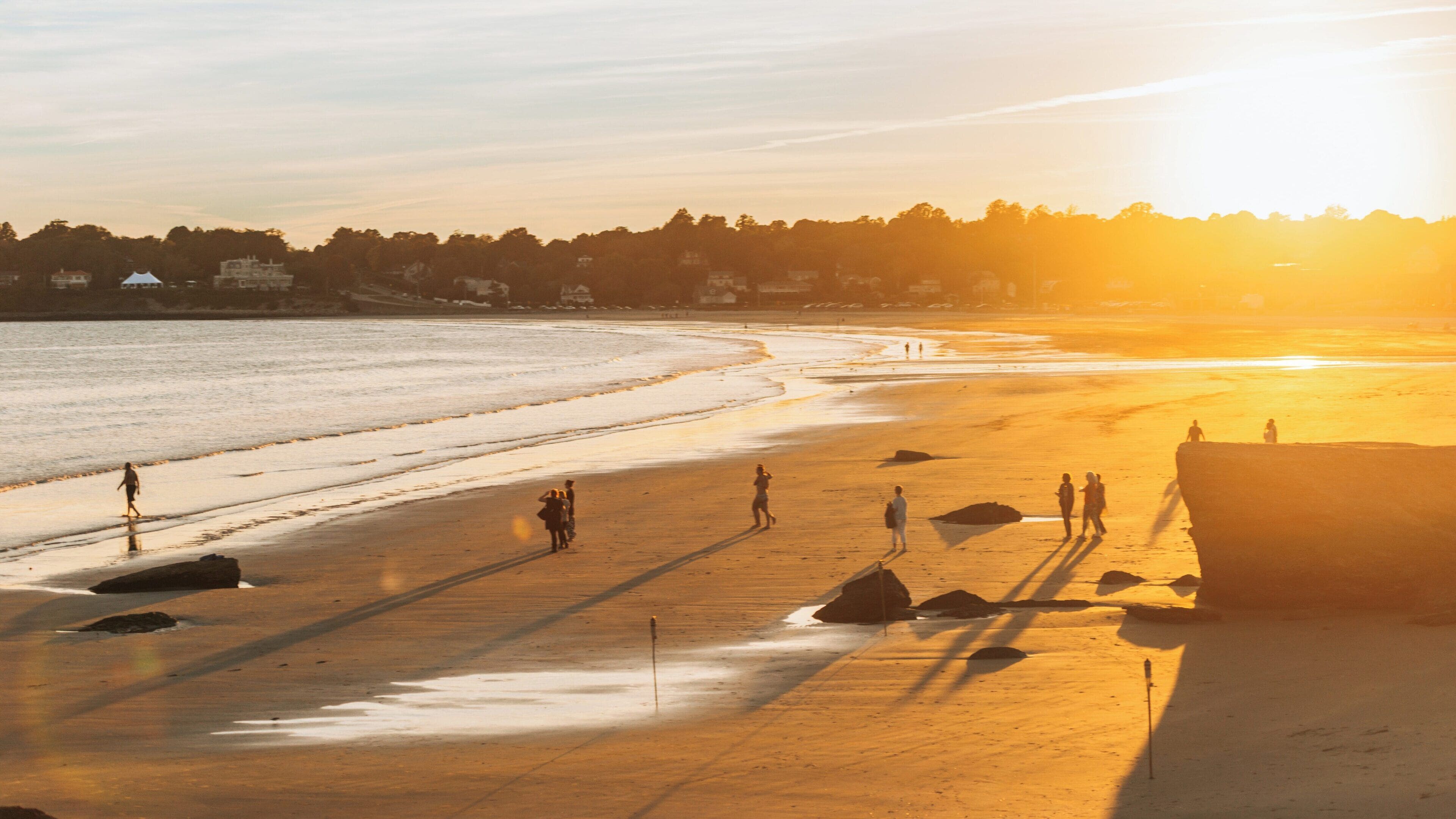 Evening strolls at Easton's Beach in Newport, Rhode Island under a warm sunset glow
