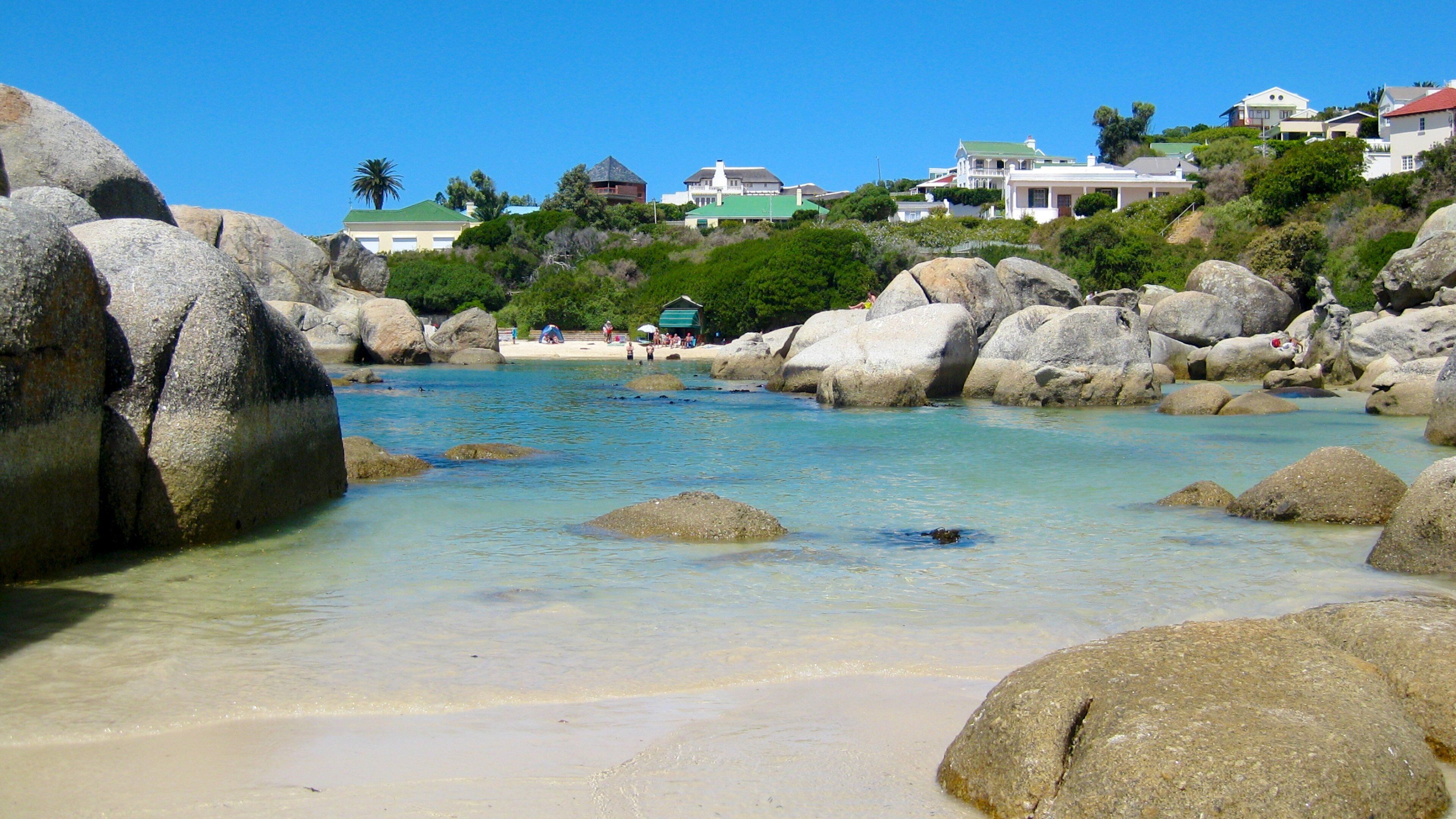 Boulders Beach which includes a coastal town, rocky coastline and landscape views