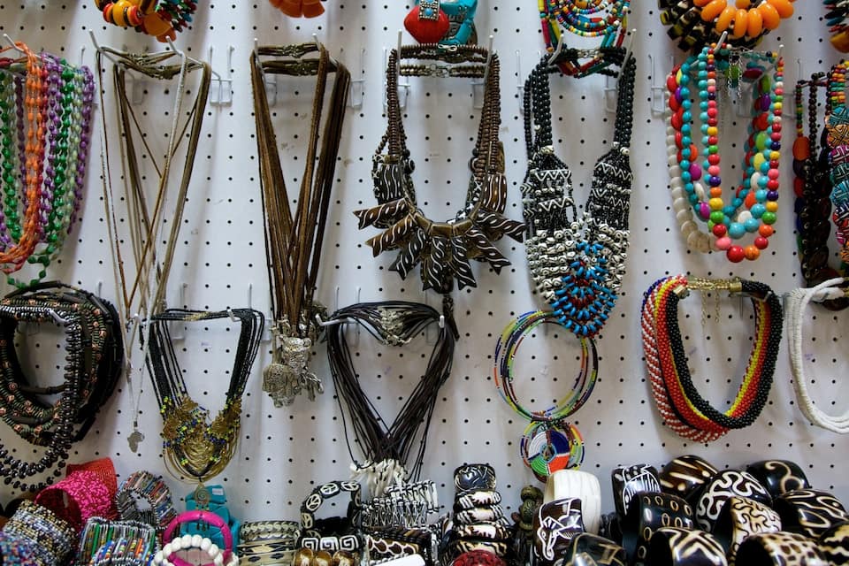 Variedad de collares y pulseras coloridas expuestas en un panel de exhibición.