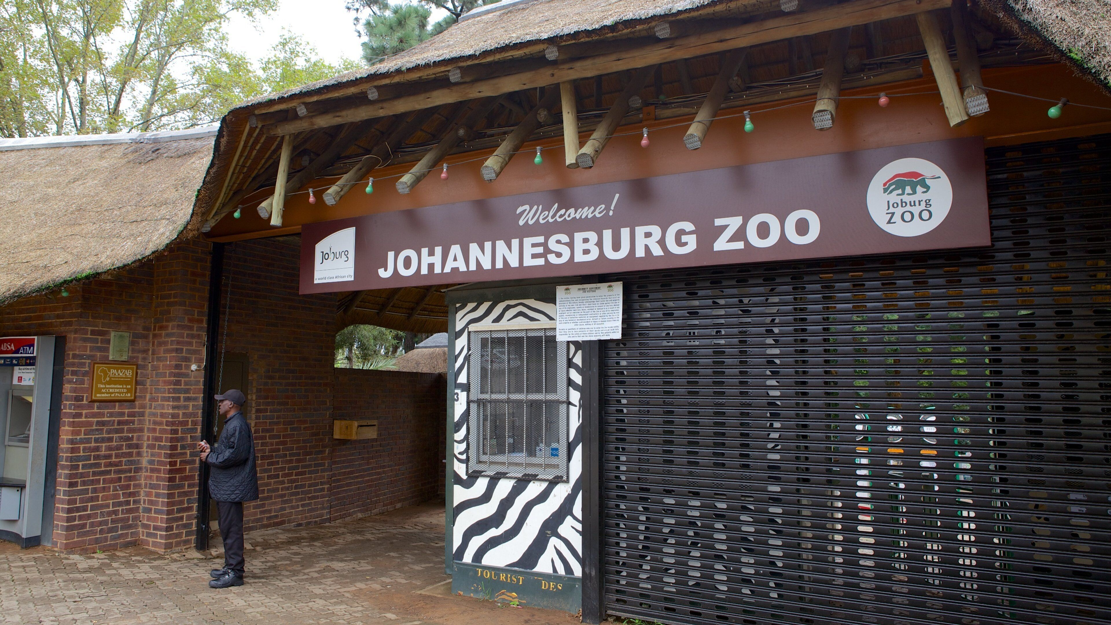Johannesburg Zoo som inkluderar zoodjur och skyltar såväl som en man