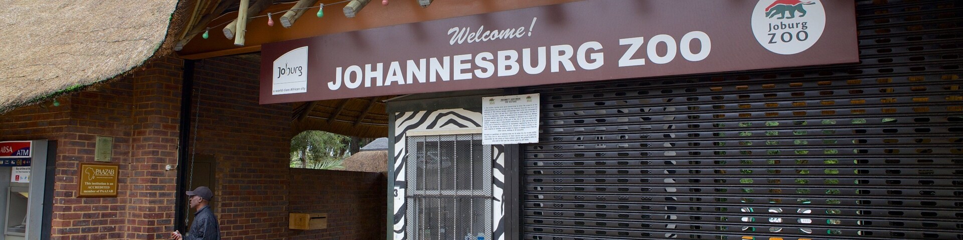 Johannesburg Zoo featuring zoo animals and signage as well as an individual male