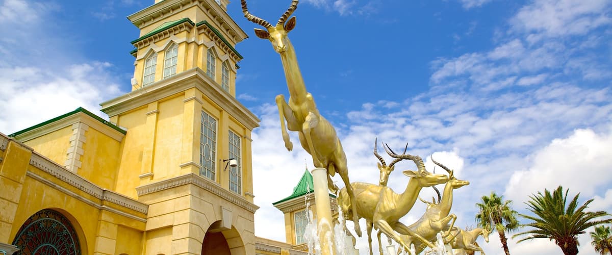 Gold Reef City showing a statue or sculpture, art and a city