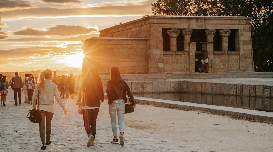 Temple of Debod featuring street scenes and a sunset as well as a small group of people