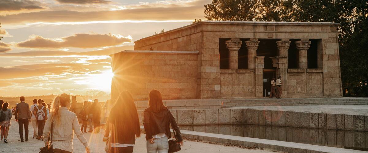 Temple of Debod featuring street scenes and a sunset as well as a small group of people