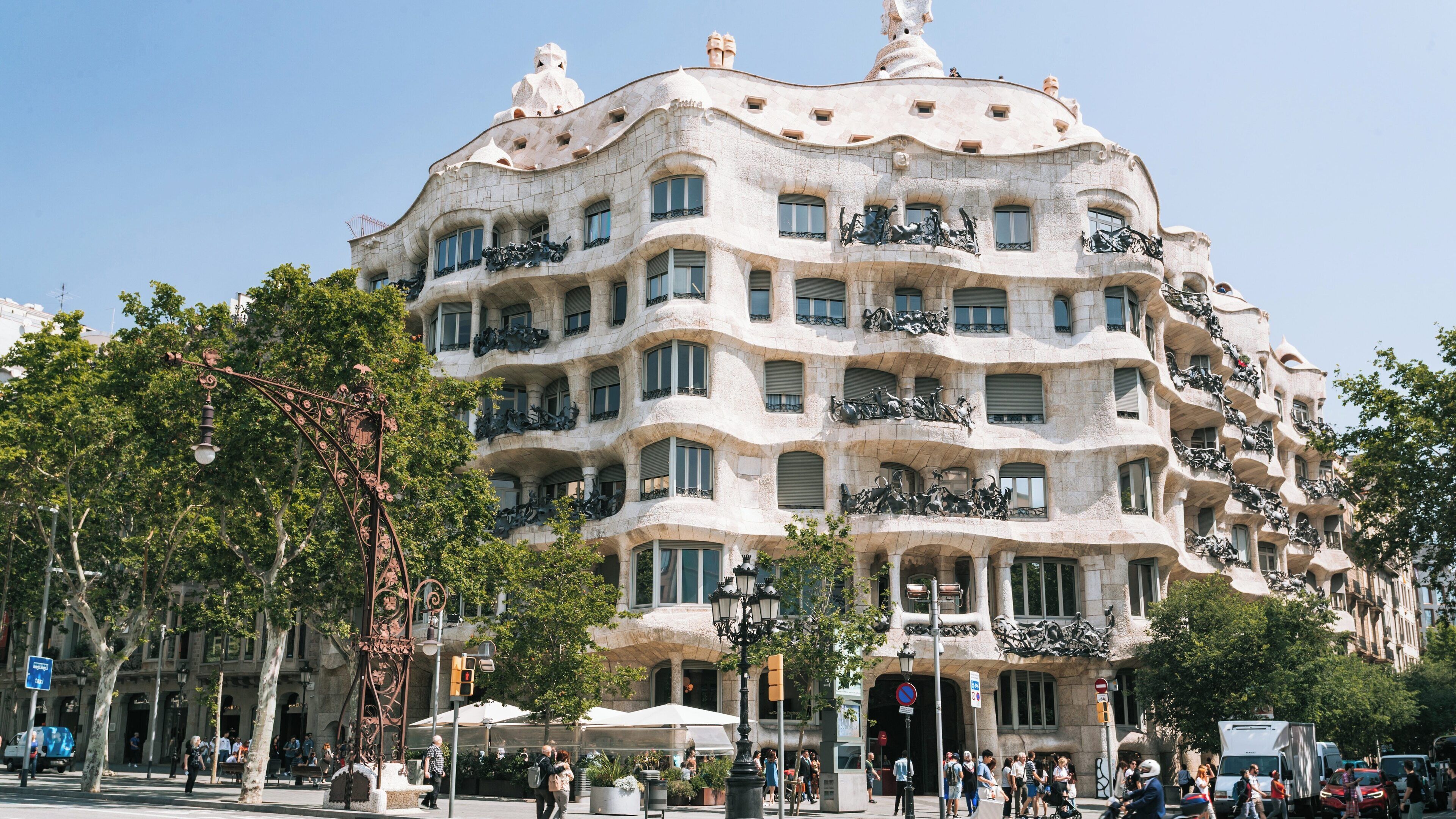 Exploring Casa Mila in Eixample, a stunning architectural gem in Barcelona, Catalonia, Spain bathed in sunlight on a clear day