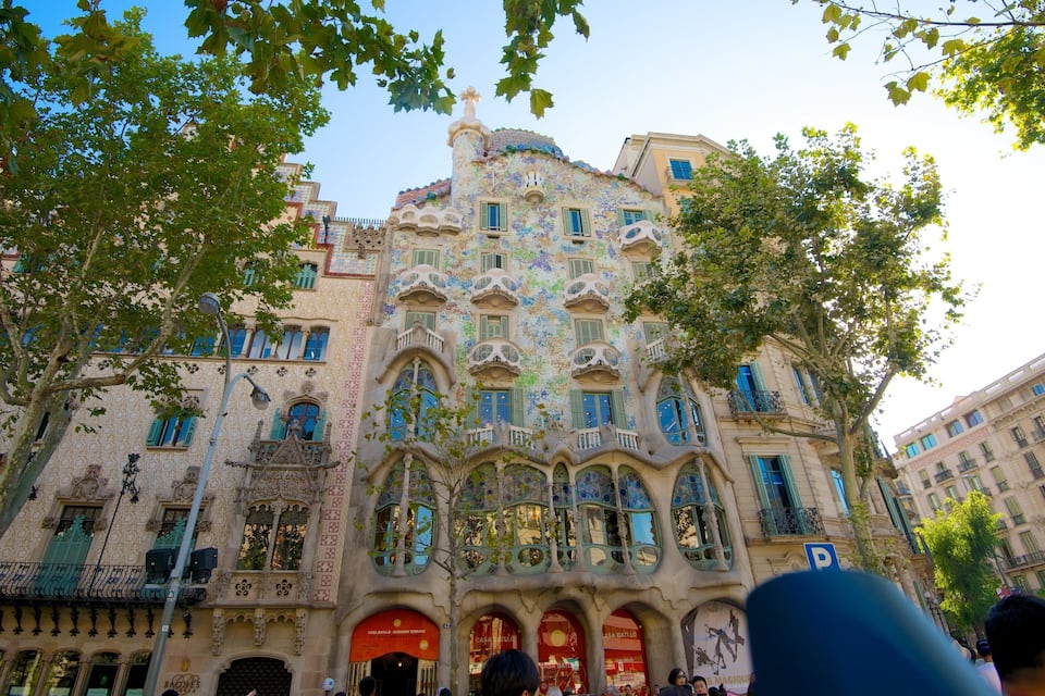 Un edifici amb detalls complexos de mosaic i balcons verds.