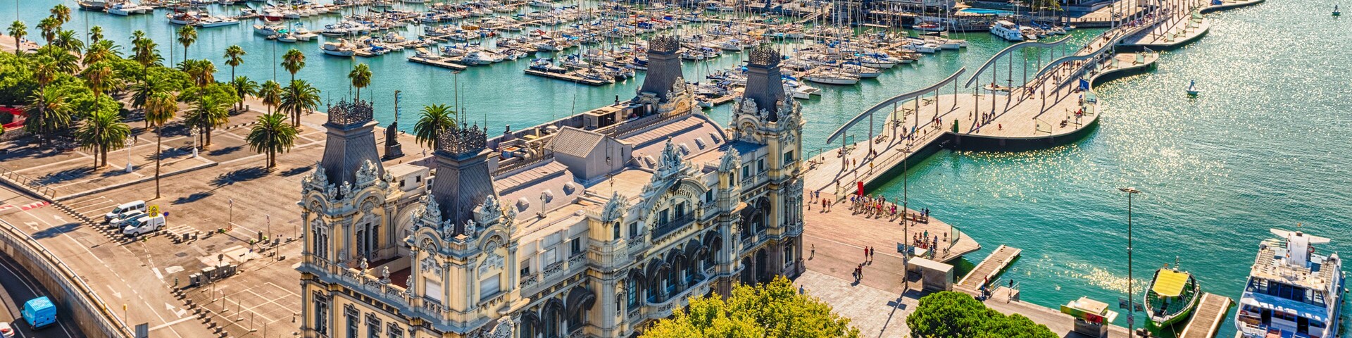 Uma marina com muitos barcos, um edifício histórico e uma orla marítima.