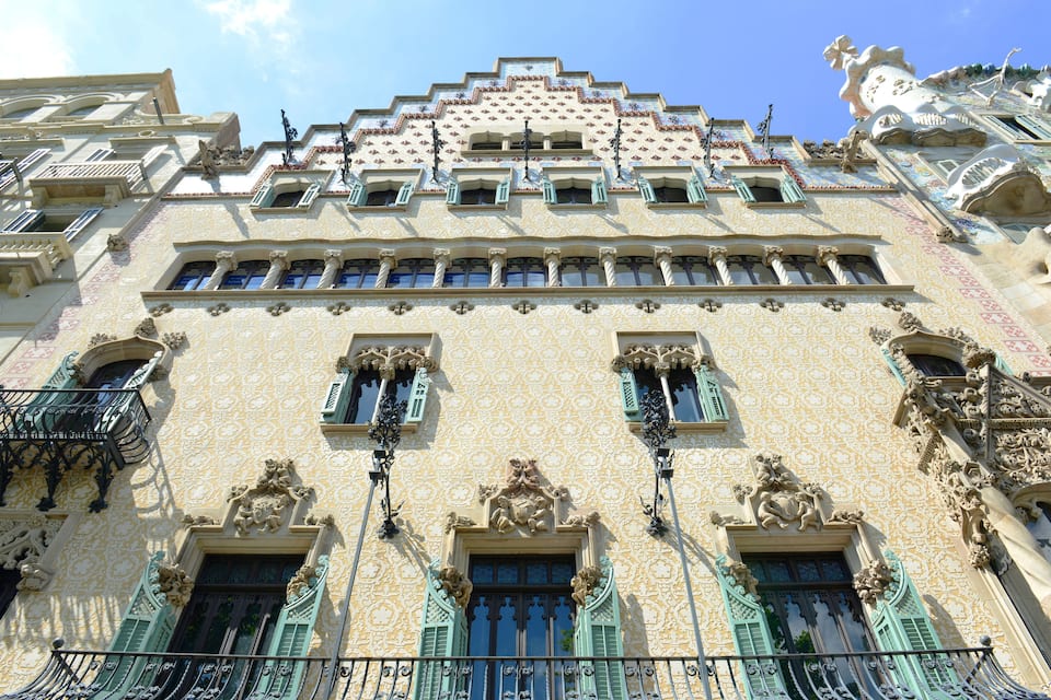 A building with ornate facades, green shutters, and intricate architectural details.