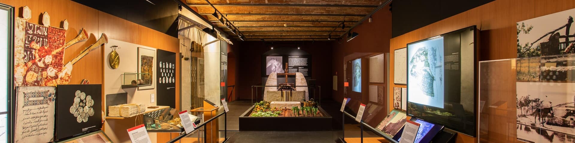 An indoor museum exhibit with historical artifacts, documents, and informational displays.