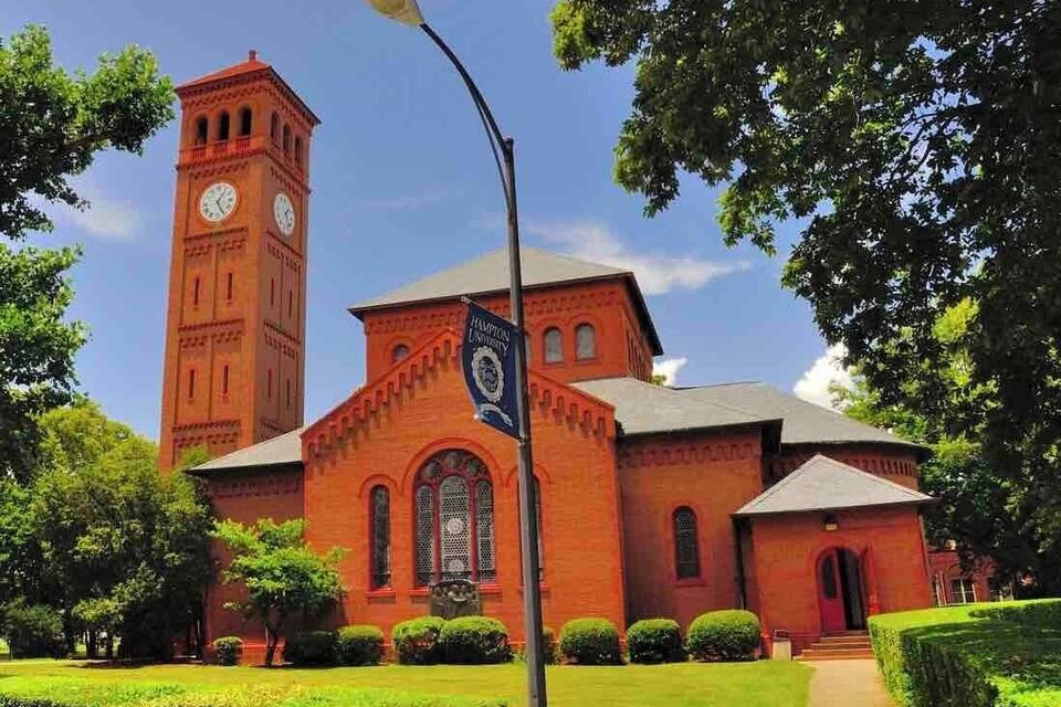 Una iglesia de ladrillo rojo con una torre de reloj y una bandera.