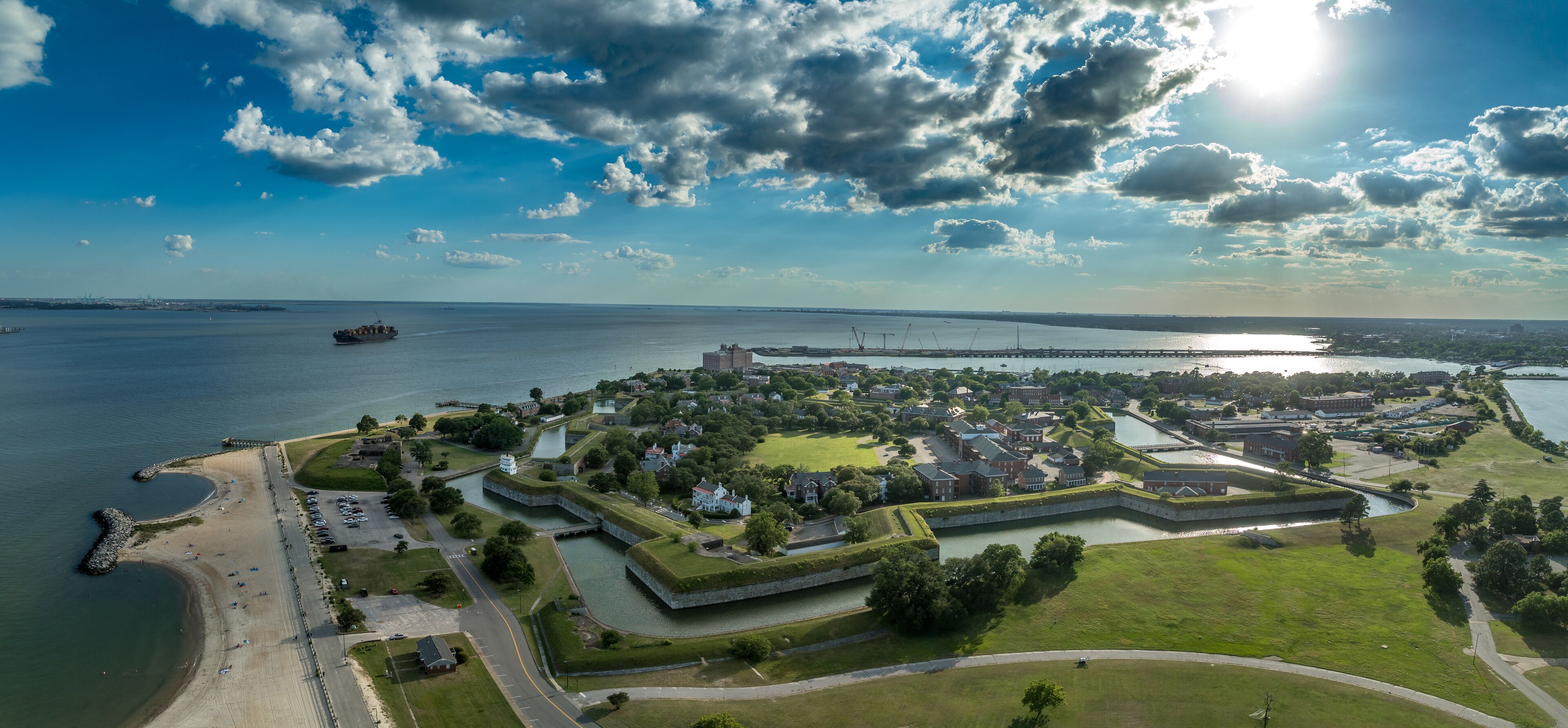A coastal town with a fort, a bridge, and a ship on the water.