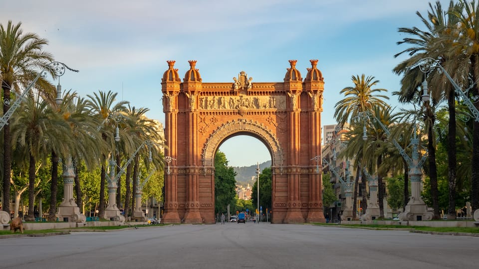 Un gran arco ornamentado con esculturas intrincadas y cielo despejado arriba.