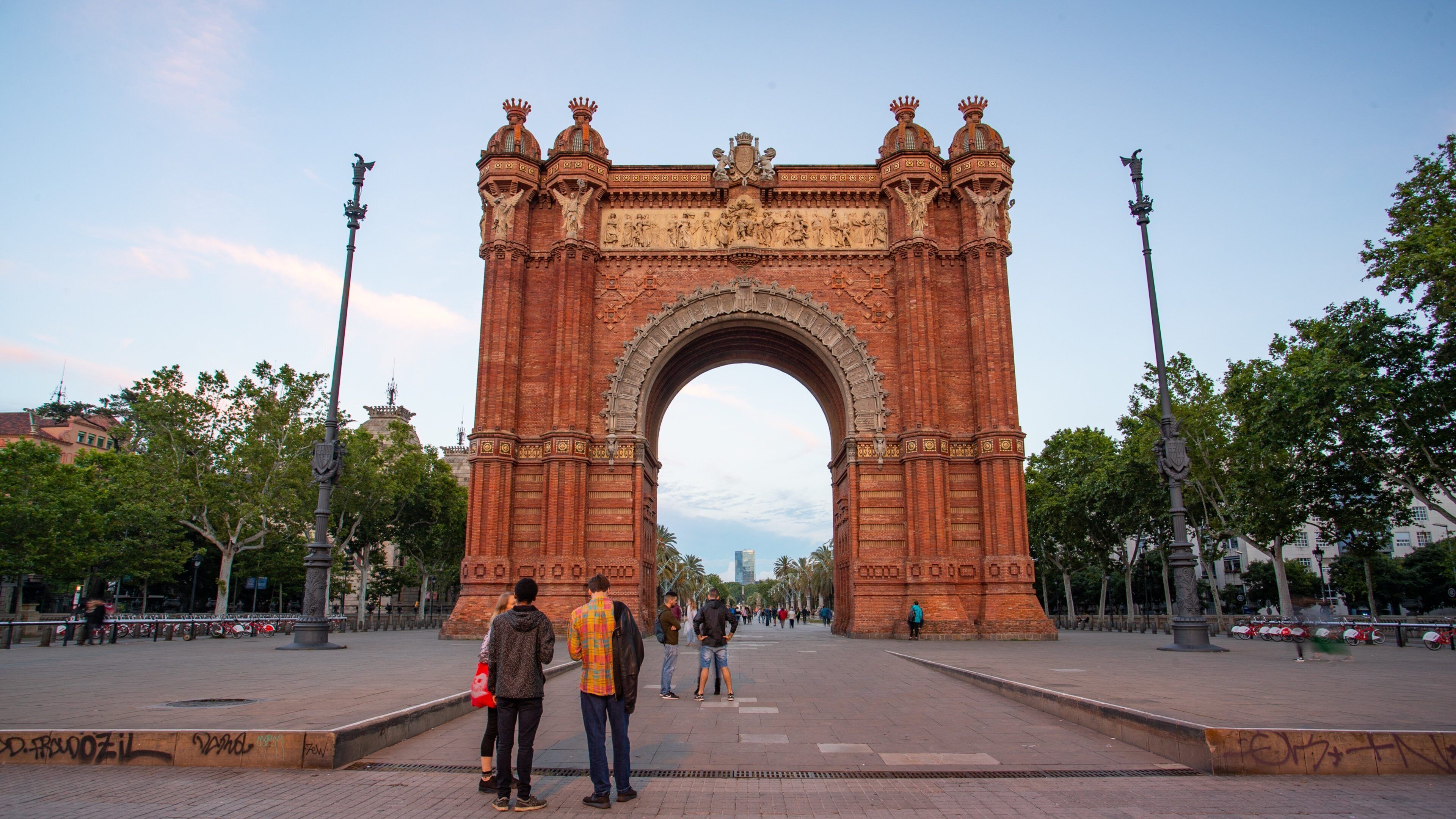 Arc de Triomf which includes heritage elements, a sunset and street scenes
