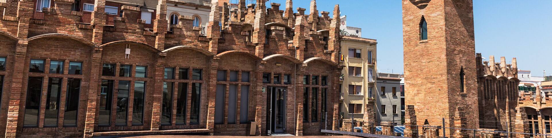 Un edificio histórico con una torre destacada y ventanas en arco.