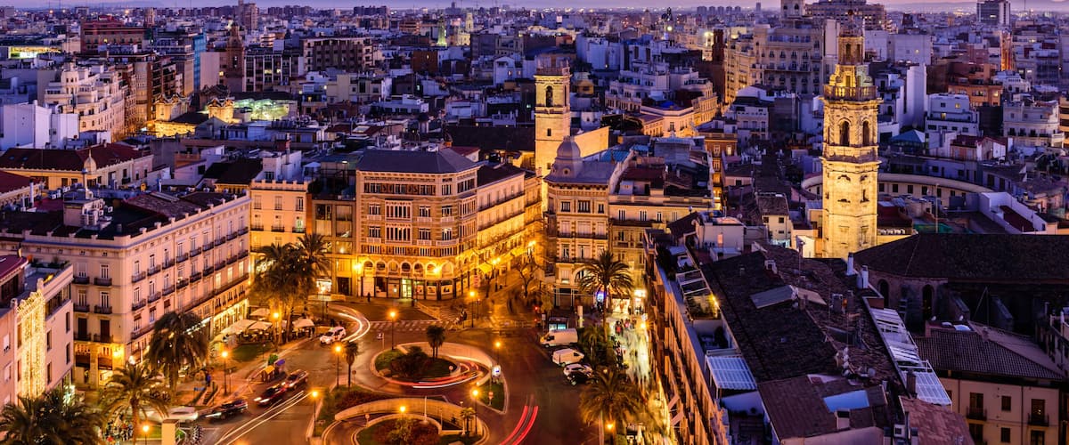 Sightseeing of Spain. Aerial view of Valencia at sunset. Illuminated Plaza de la Reina, cityscape of Valencia.